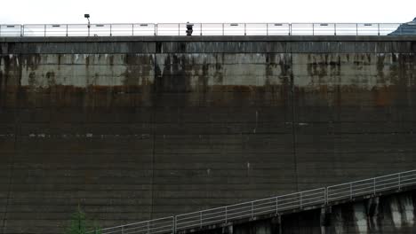 pedestal up of person walking on top of fellaria dam of valmalenco in italy