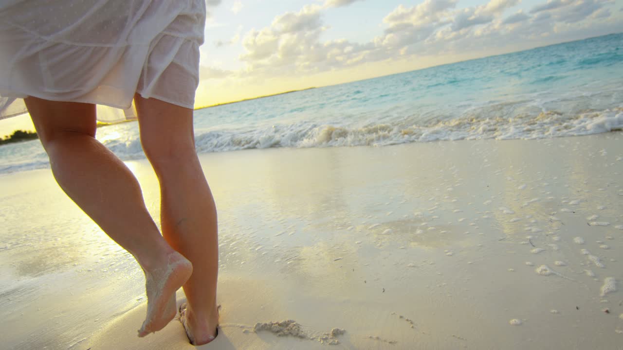 piernas de mujer caucásica descalza disfrutando de la puesta de sol de la isla