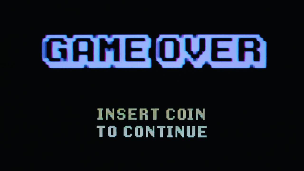 Real TV capture: a retro vintage 8-bit game over screen with blocky pixelated text