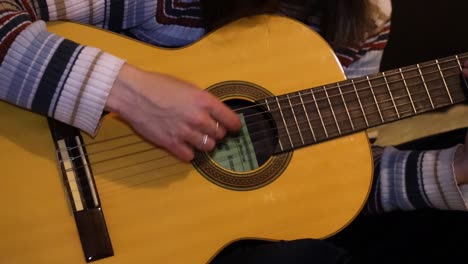 chica de cerca a cámara lenta practicando guitarra en la cama