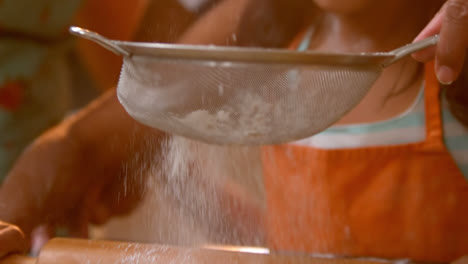 niña preparando masa de galletas con su madre en la cocina
