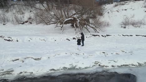 Couple playing in the snow establishing shot winter landscape icebergs on a frozen water surface