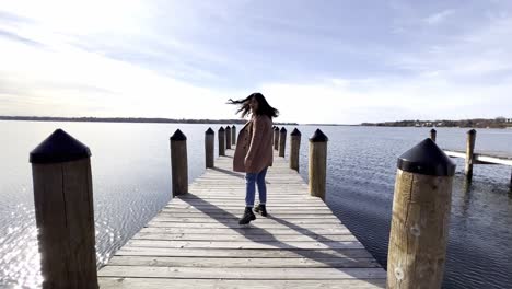 niña caminando en un muelle de cubierta en un lago