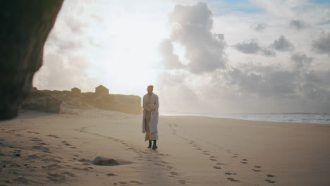 modelo pacífico caminando playa de arena dejando huellas. mujer de viaje volviendo