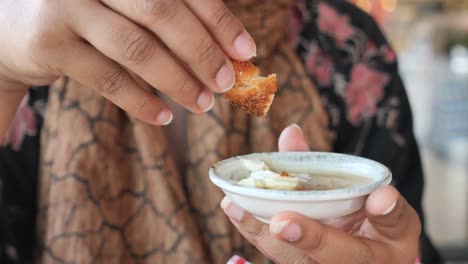 woman eating a piece of bread with butter and honey