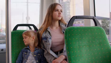 tired sleepy woman with daughter fall asleep in public tram going home after hard working day