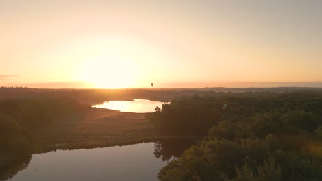 Drone-shot-of-a-Hot-Air-Balloon-during-a-scenic-landscape-in-sunset,-aerial-view-dolly-in