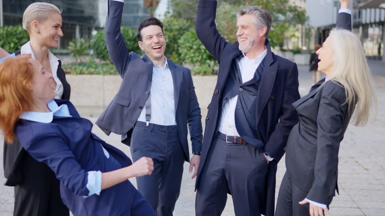 Happy business team celebrating success outdoors