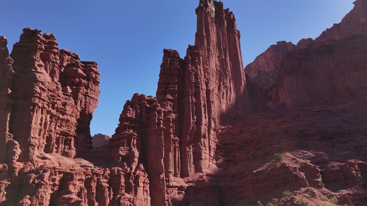Drone che vola verso il pinnacolo con la telecamera che si inclina verso l'alto alle Fisher Towers a Moab, USA, in 4K