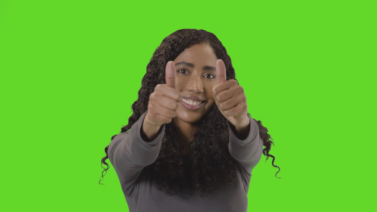 Studio Portrait Shot Of Woman Giving Double Thumbs Up Sign Against Green Screen 1