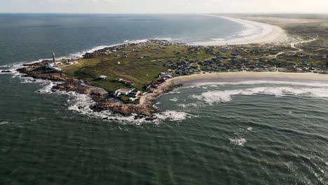 aerial view orbiting cabo polonio shimmering seascape and island lighthouse on the lush uruguay coastline