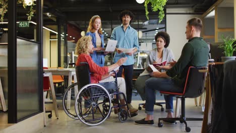 Happy-disabled-and-diverse-business-people-discussing-work-at-office