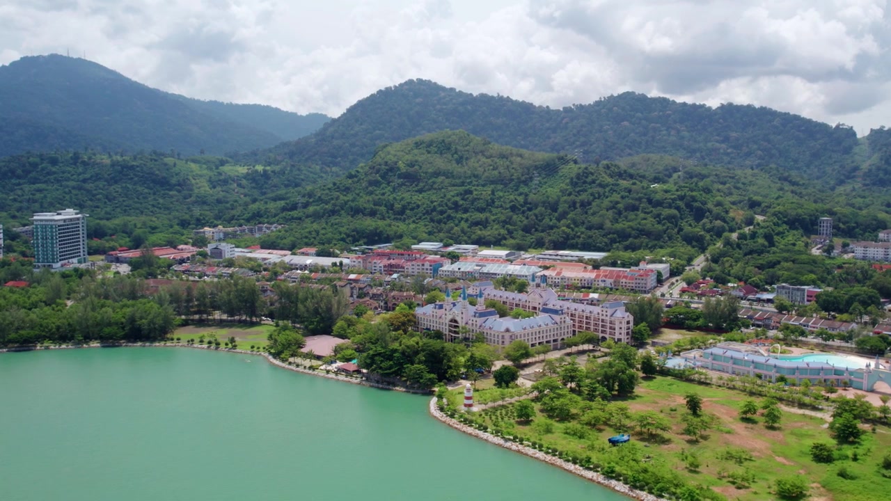 Kuzey Malezya'da Langkawi'nin pitoresk sahil şeridini, zümrüt rengi koyunu, tropikal yağmur ormanı dağlarını ve kıyı şehir manzarasını gözler önüne seren akıcı alçalan drone çekimi