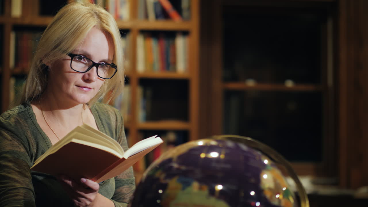 una mujer mira un hermoso globo en la biblioteca