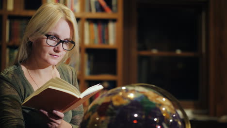 a woman looks at a beautiful globe in the library