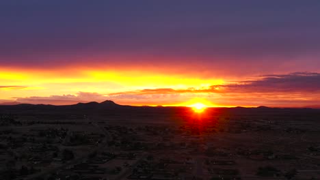 brilliantly golden sunrise over california city in the mojave desert - aerial time lapse