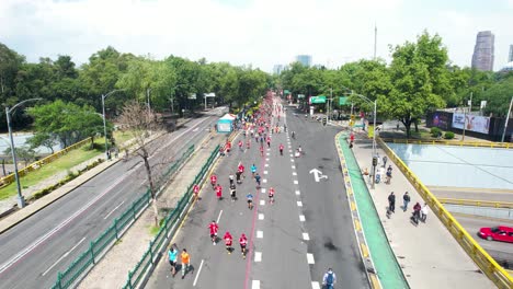 backwards drone shot of the city marathon runners as they pass through the main avenues of the city