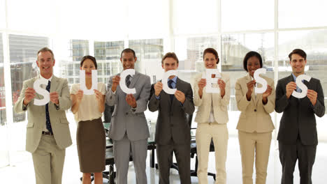 equipo de negocios con cartas deletreando el éxito