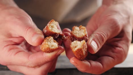 primer plano de una mano sosteniendo rosquillas en rodajas
