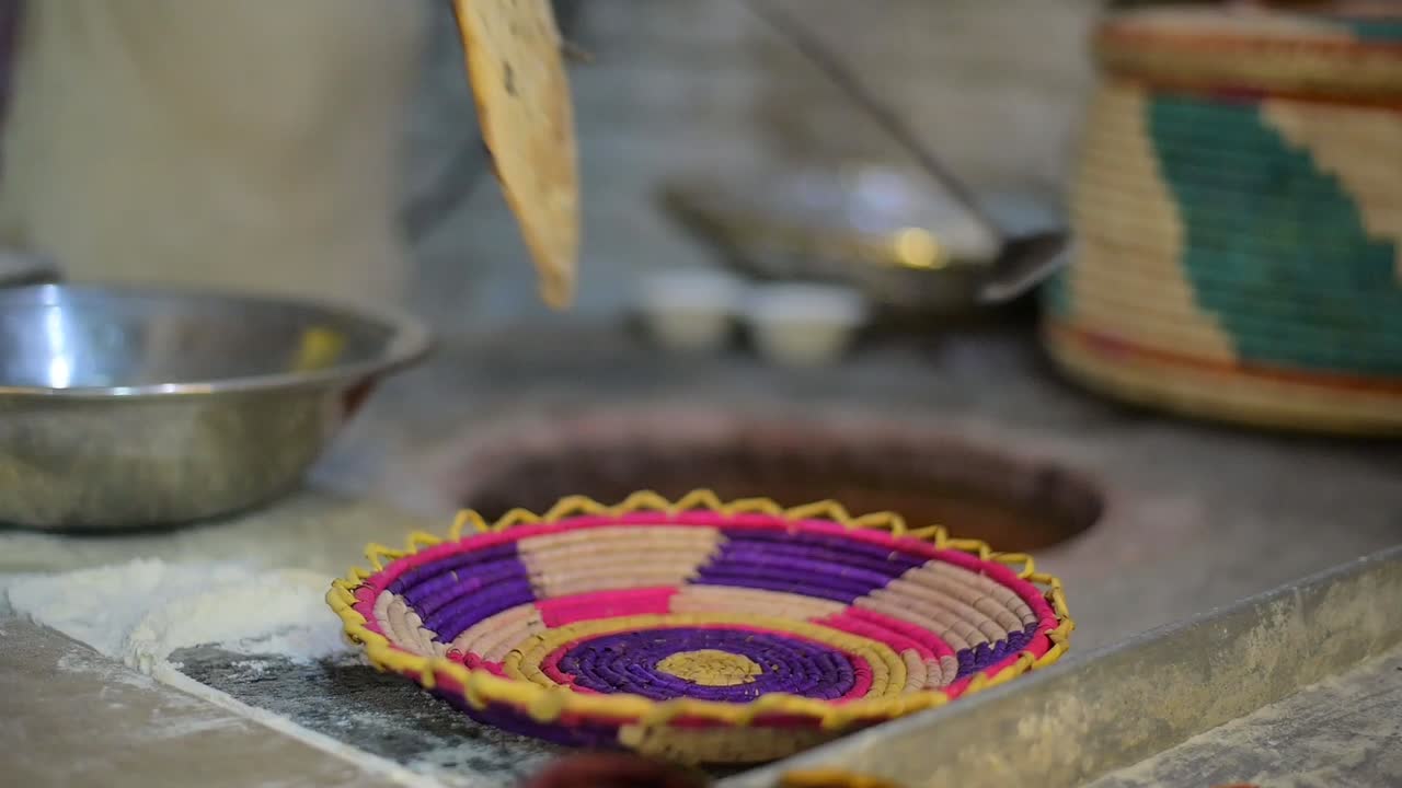 hombre haciendo naan en un horno de tandoor