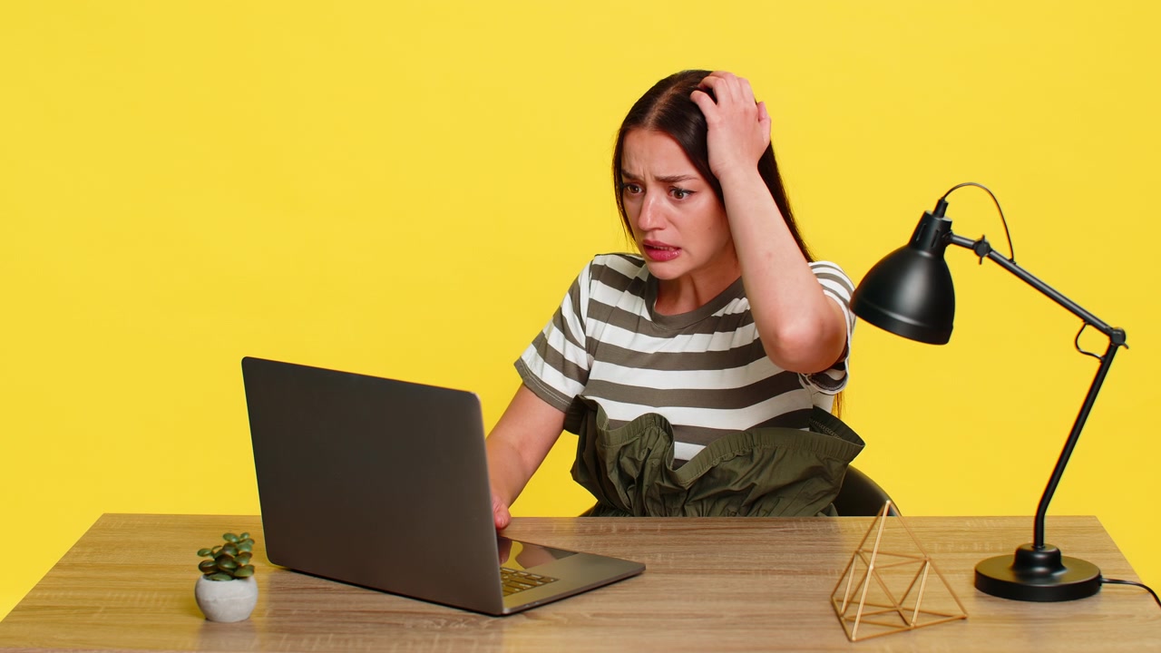 Woman angrily typing then slamming laptop shut frustrated by error bug or system crash at table