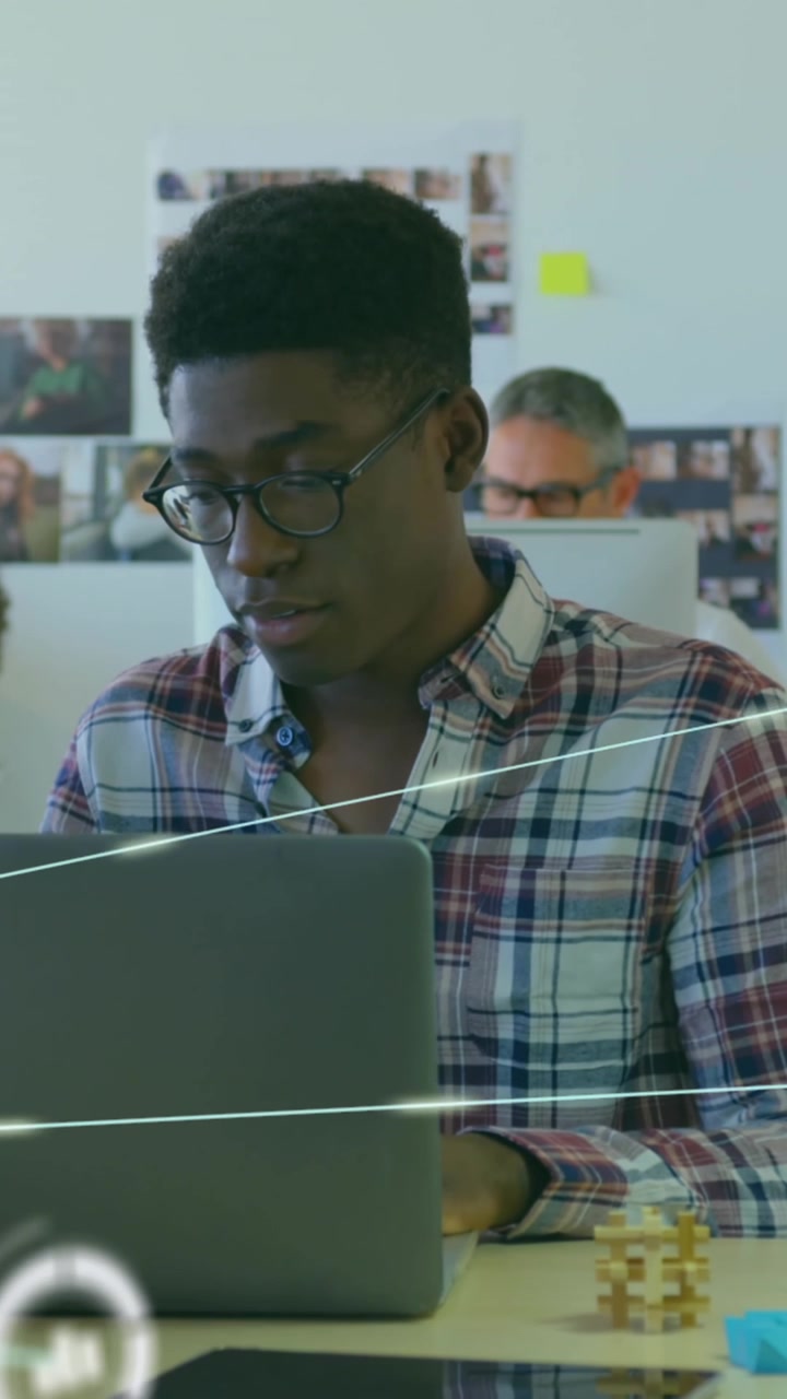 Animation of connected globe icons over diverse coworkers discussing reports on laptop in office