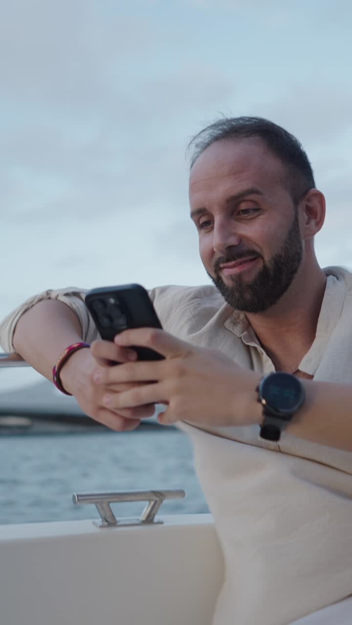 Man on a yacht using his phone