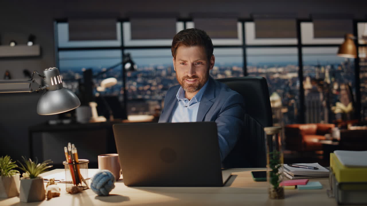 lächelnder geschäftsmann, der kaffee trinkt, büro-nacht-close-up. boss sucht laptop