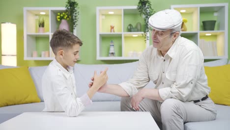 Grandpa-holding-arm-wrestling-with-his-grandson.-Grandfather-and-grandchild-intimacy.