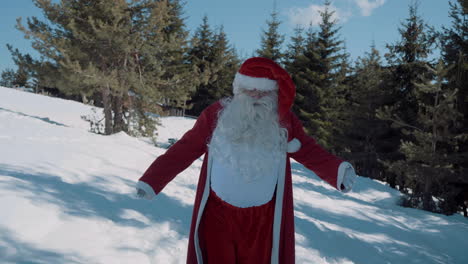 santa walks with outstretched arms to the camera on a snowy field