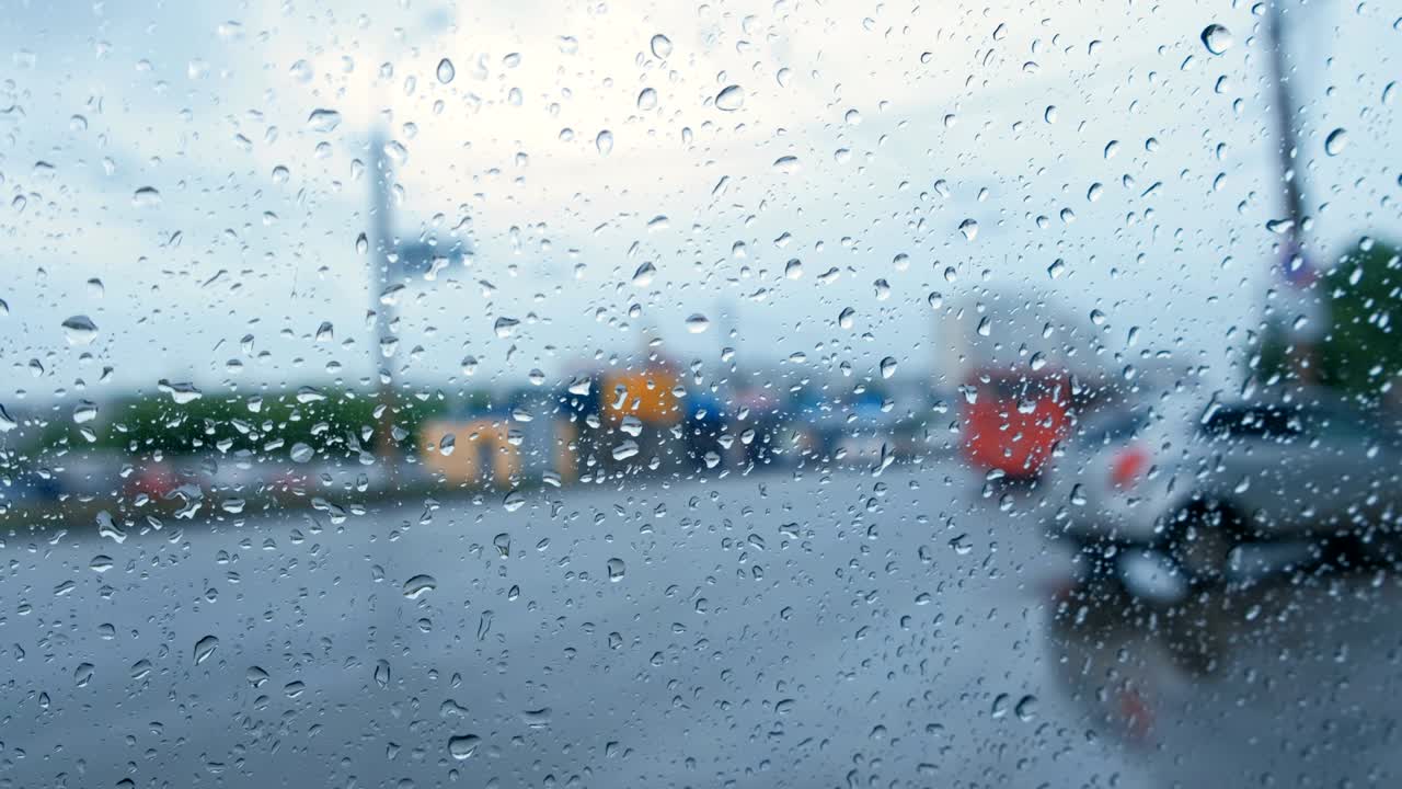 비가 내리는 차 창문에서 도로를 볼 수 있습니다. 흐릿합니다.