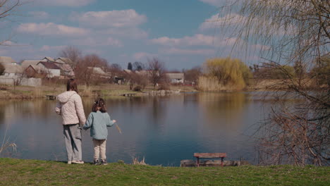 two sisters by a pond in spring