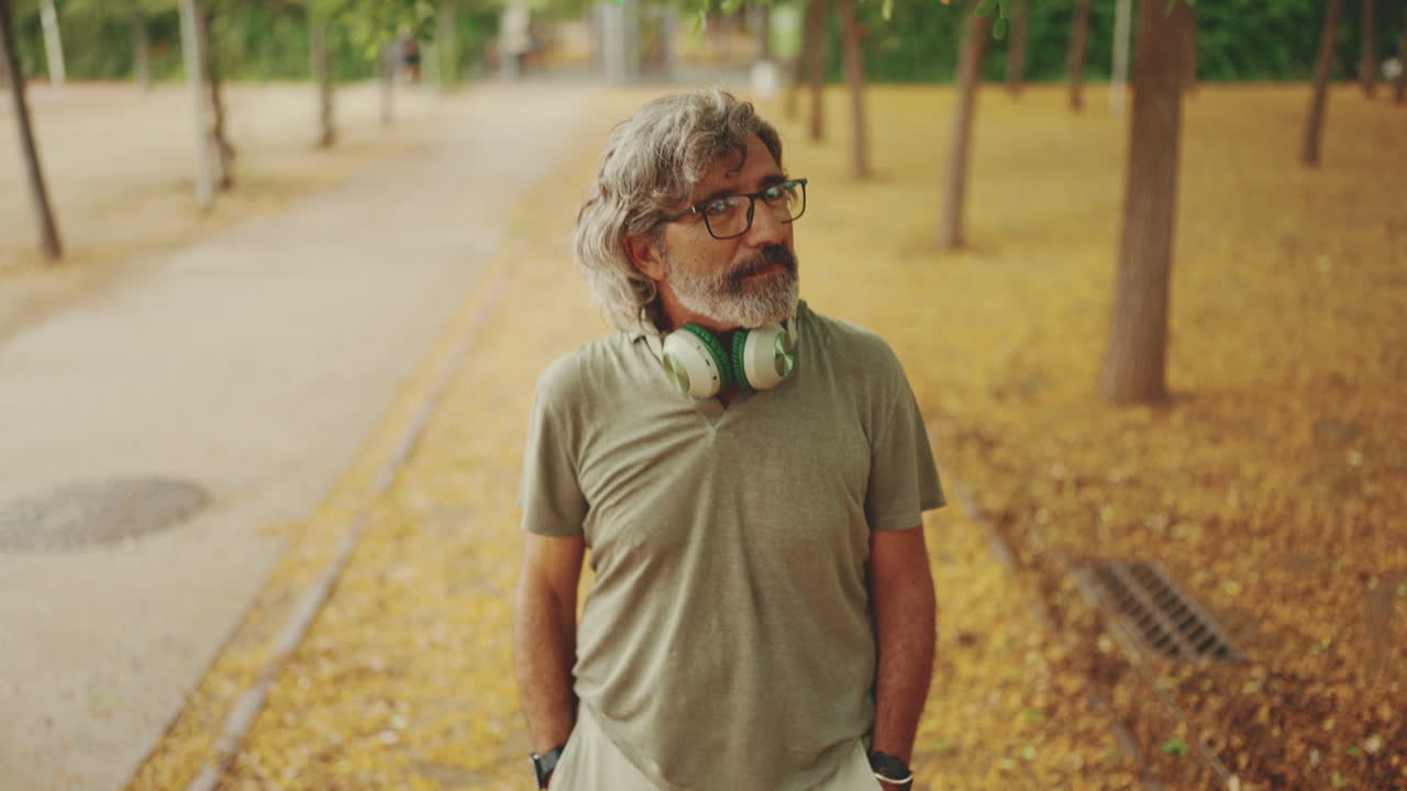 Middle-aged man walking in a park during autumn