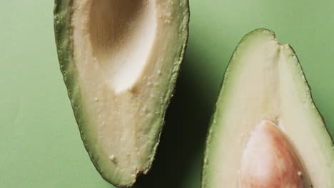 video of sliced avocado with copy space over green background