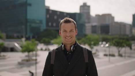 portrait of successful young caucasian businessman executive smiling happy at camera looking confident in urban city background