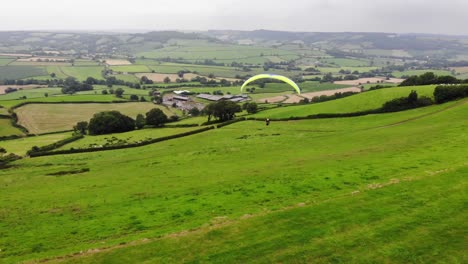 Aerial-shot-of-a-Paraglider-just-taken-off-from-a-hill-in-England