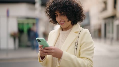 young woman smiling confident using smartphone at street