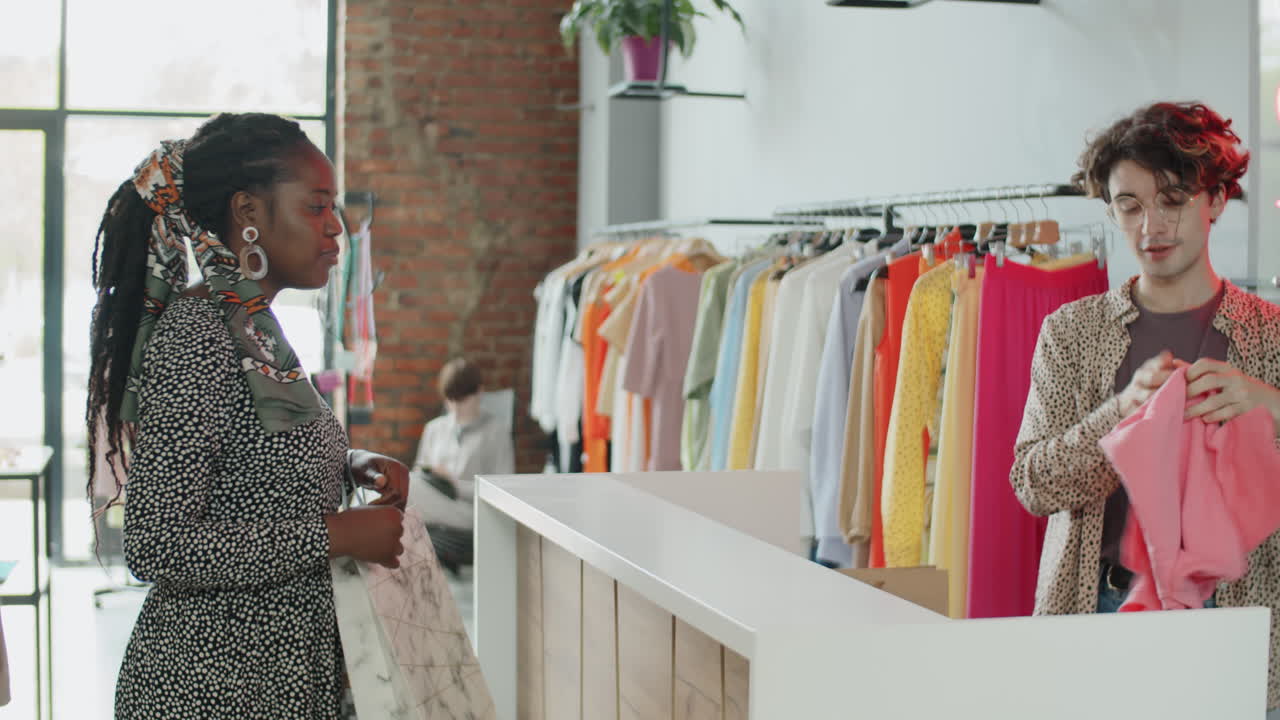 joven mujer afroamericana comprando prendas nuevas en una tienda de ropa