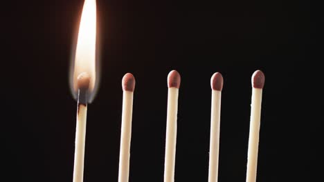 Video of close up of matches with yellow fire flame and copy space on black background