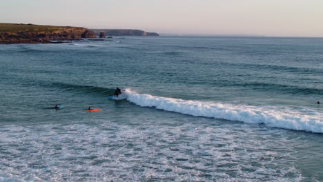 Surfers enjoying the waves by the beach in Cornwall, UK