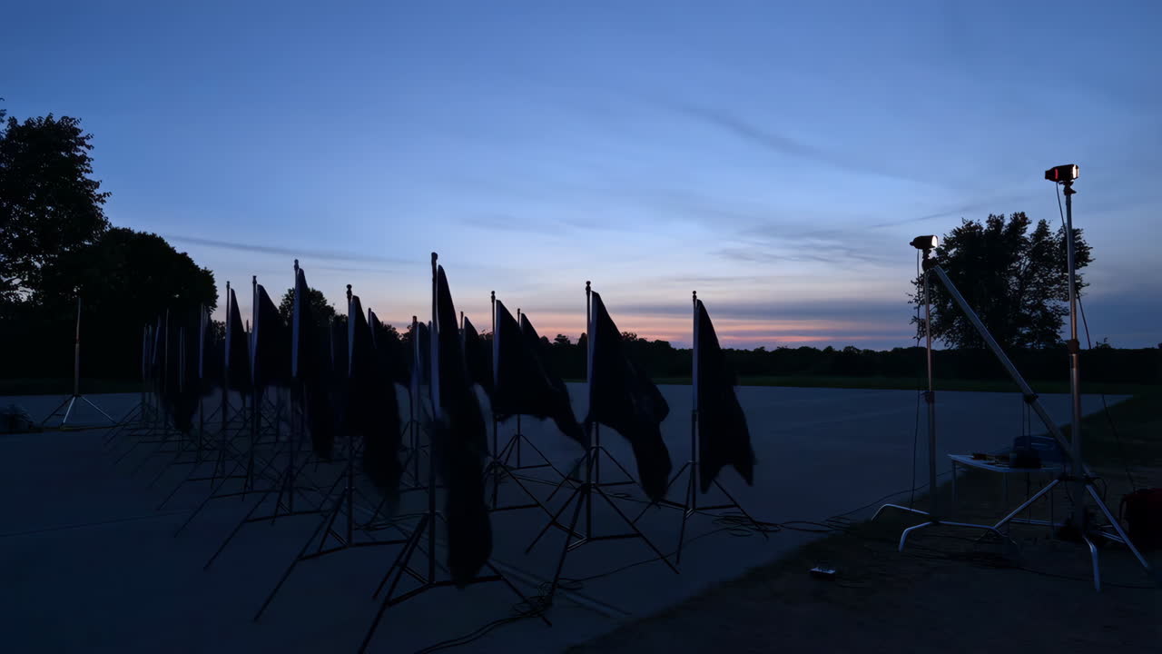 Flags and photography equipment set up at dusk or dawn