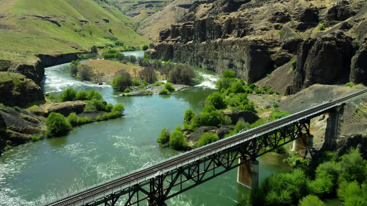 US, Oregon, Maupin, Deschutes River, 2025-05-08 - Drone view on the Deschutes River of a train bridge at Twin Crossings which is two bridges and a tunnel. In north central Oregon in spring