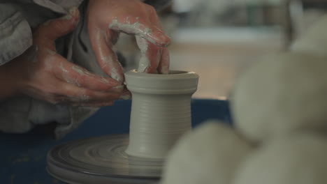 this person is preparing a pot with wet clay