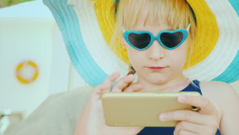 The-Niño-Relaxes-After-Swimming-In-The-Pool---Plays-On-The-Smartphone