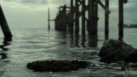 Broken-Concrete-Slap-Water-Dilapidated-Pier-Blurry-Background