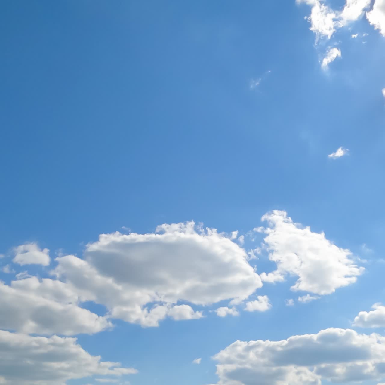 Light white clouds covering the sun from time to time. Cotton puffy cloudscape timelapse