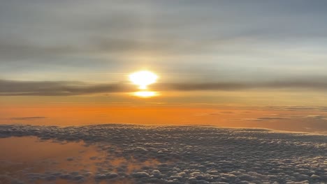 a nice sunset over the clouds with a colorful sky shot from a jet cockpit in a real flight