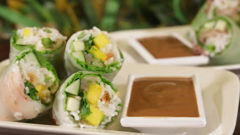 colorful stacked rice paper rolls with peanut sauce, slider slow motion 4k