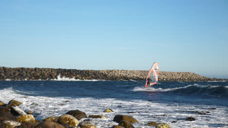 toma panorámica de un windsurfista noruego, surfeando una ola y luego patea, cae y se recupera, en el mar del norte, en el océano atlántico, en un día soleado de verano, en lista, sur de noruega