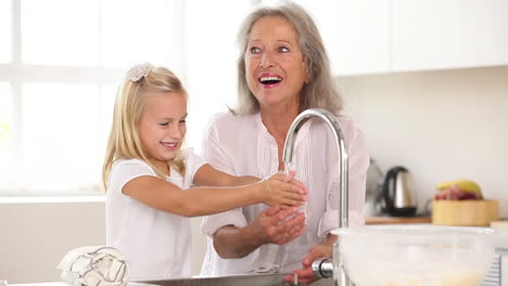 Happy-grandmother-and-granddaughter-washing-hands